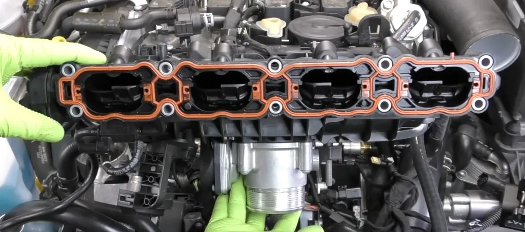 EA888 Gen 3 intake manifold removed showing orange seals — video frame from HumbleMechanic technical guide