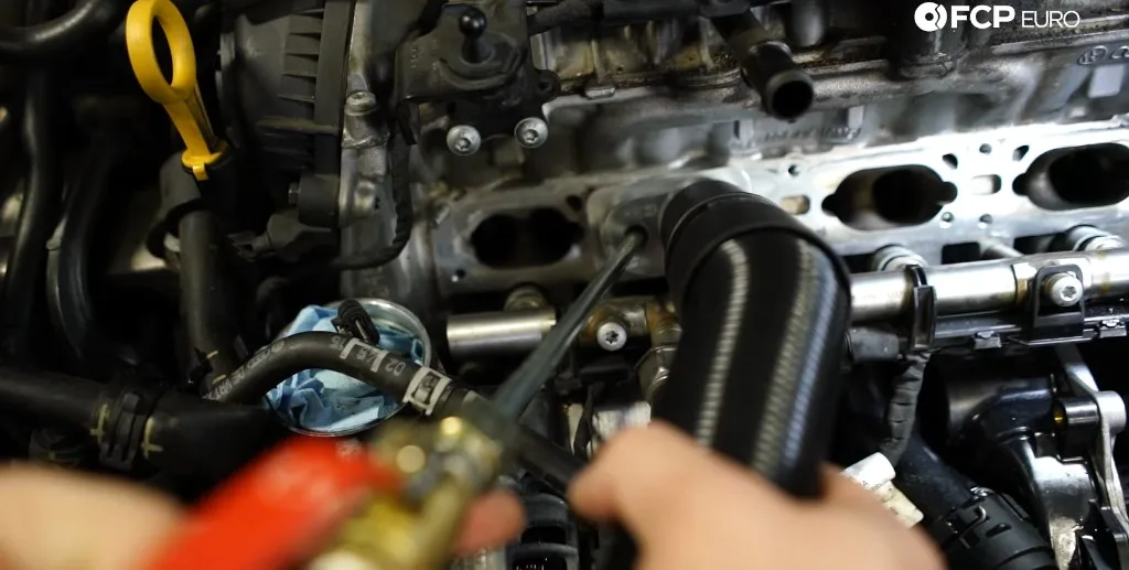 EA888 Gen 3 intake valve walnut blasting in progress — port vacuum adapter and blaster wand. Technical frame from FCP Euro